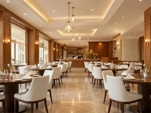 Restaurant dining hall with round tables and cream chairs at Barsana Resort